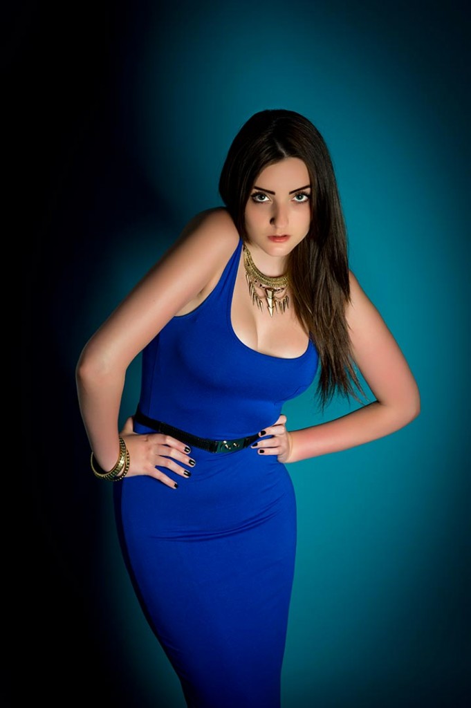Dramatic fashion portrait of model in blue dress against blue background shot in the studio